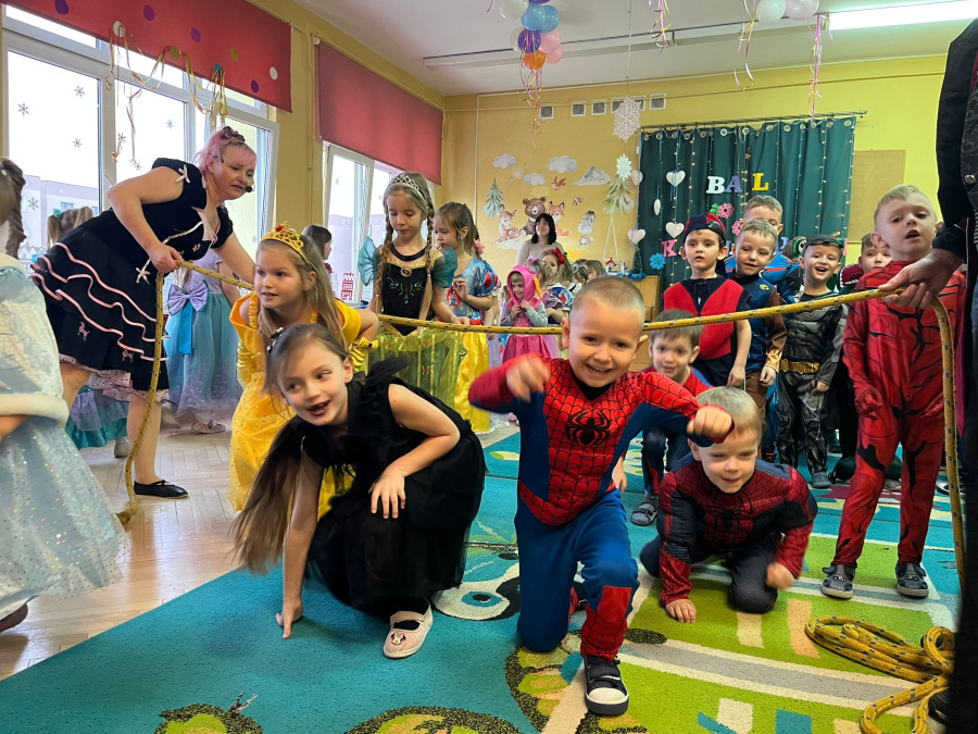 Dzieci w przebraniach bohaterów bajekbiorą udział w konkurencji przechodzeniu pod zawieszoną linąjpg